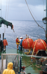 Group in rain gear working on deck of Charles Darwin