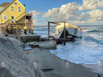 A coastal home falls into the ocean due to n'oreaster erosion.