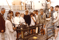 Columbus Iselin (far left) and Jan Hahn (far right with pipe) with students on dock in front of