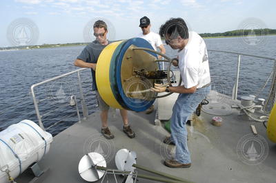 Dave Ralston and Jim Lerczak carry a mooring to the bow.