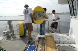 Malcolm Scully and Jim Lerczak carrying a recovered buoy
