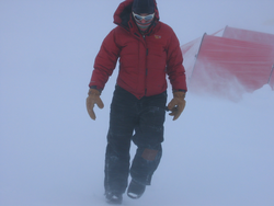 Ali Criscitiello walking across the ice in blowing snow.