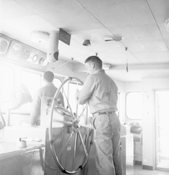 Ed Pierce at wheel aboard the Atlantis II