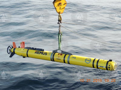 REMUS 600 suspended over the water surface during deployment.