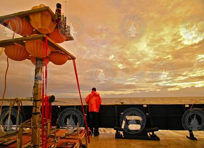 Researcher looking out to see from Atlantis during a bright orange sunset.