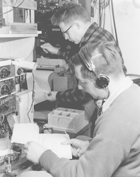 Hartley Hoskins and Karl Schleicher (with headset) working in lab aboard Crawford
