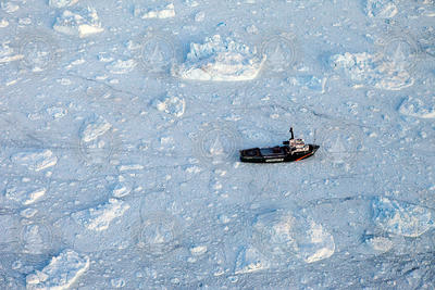 Greenpeace vessel, Arctic Sunrise, passing through an icy fjord.