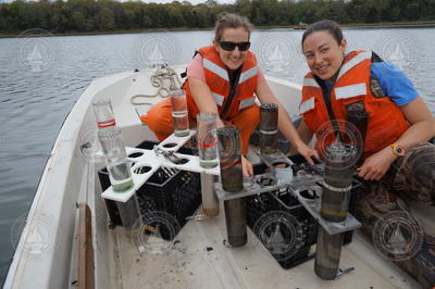 Alice Albert and Alexis Fischer in a small boat with recovered sediment traps.