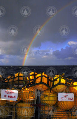 Rainbow beyond flotation balls in crates on ship deck.
