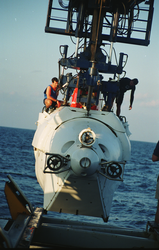 Bruce Strickrott (left) perched on top of Alvin during recovery to deck.