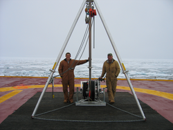 Kris Newhall and John Kemp on deck with Ice-Tethered Profiler (ITP) deployment tripod.