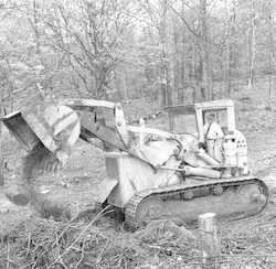 Paul Fye operating bulldozer at Quissett Campus groundbreaking.