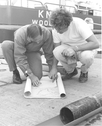 Charley Hollister and unidentified man looking at chart on the WHOI dock