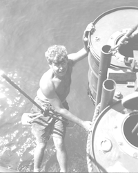Maurice Ewing working on the deck of the Atlantis with large water drums