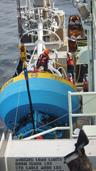 Meghan Donohue sitting on an OOI Global Array buoy while rigging it.