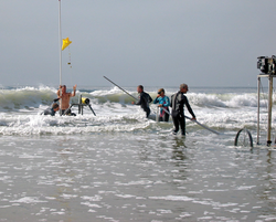 Researchers setting up instrumentation in the surf.