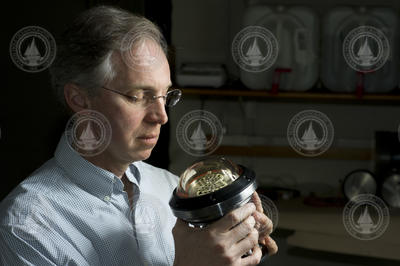 Norm Farr holding a component of his optical modem system.