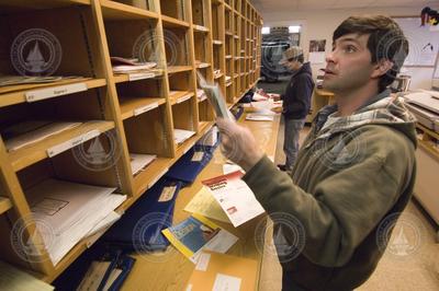 Patrick Harrington sorting mail in the warehouse mailroom.