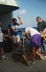 Dan Fornari (purple shorts) preparing a sediment grab sampler.