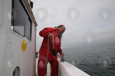 Alex Bocconcelli deploying a recording device in Wellfleet Harbor.