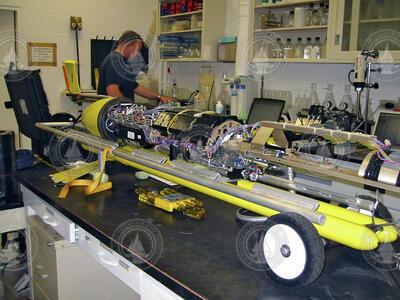 Thermal glider in pieces on a lab bench with John Lund in background.