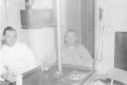 Eugene Mysona and Jack Merchant sitting in galley