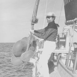 Unidentified man putting current meter over the side of Ocean Pearl