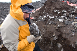 Adam Soule examining a rock specimen.