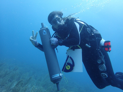 Laura Weber using a Niskin bottle to collect water samples while diving.