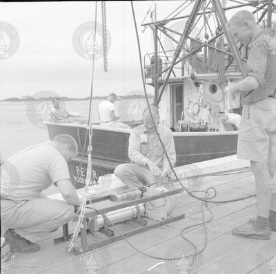 Harold Edgerton and unidentified people working on pinger at WHOI dock