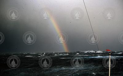 Rainbow over a rough open ocean.