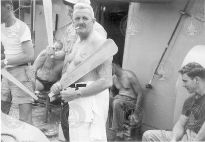 Equator line crossing ceremony, Rowland Pearson holding paddle