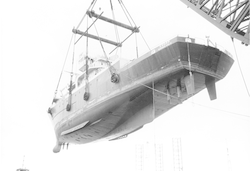 View of hull, Knorr suspended by large crane