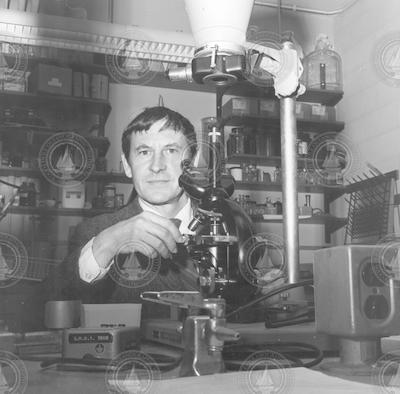 Robert Guillard behind a microscope in laboratory
