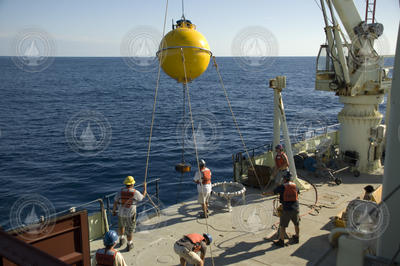 Subsurface mooring operations crew recovering a buoy.