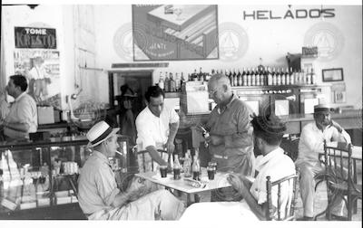 Hans Cook on left and H. Mandly, standing, in a restaurant