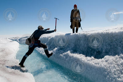 Mark Behn crossing a stream as Ian Joughin looks on.