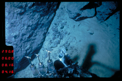 Water sampler near rocks and mud viewed during Alvin dive 1008.
