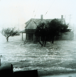 Storm surge damaging a coastal home.