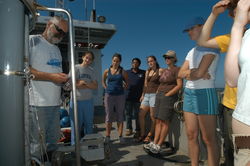 Hovey showing students how to retrieve a water sample.