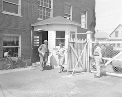 Henry Bigelow passing through guard shack at Bigelow building wartime security gate.