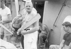 Equator line crossing ceremony, Rowland Pearson holding paddle