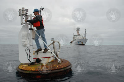 Jeff Lord working on top of a buoy out on the open ocean.