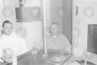 Eugene Mysona and Jack Merchant sitting in galley
