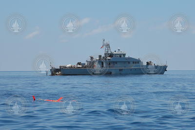 Spray Glider operating on surface in foreground off Seychelles Islands.