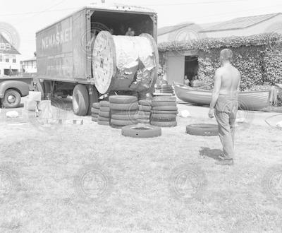 Unloading wire from a truck beside Penzance garage.