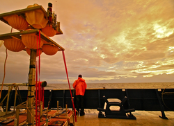 Researcher looking out to see from Atlantis during a bright orange sunset.