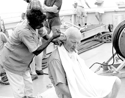 Earl Hays getting a haircut on deck, Atlantis II in Bombay