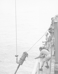 Retrieving piston coring tube from deck of Chain