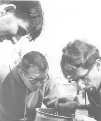 Three men looking over specimens aboard the Atlantis